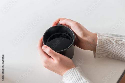 Young girl holding a cup of hot coffee. 