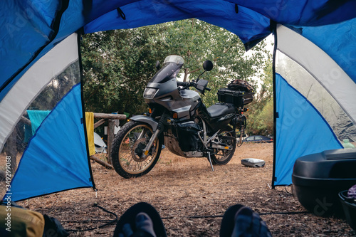 in a touristic tent. First-person view. Camping on a motorcycle. Motobike for long journeys is in the center of the frame. The concept of vacation and extreme relaxation, a hobby.