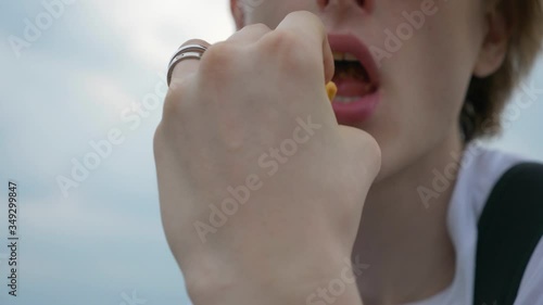 Wallpaper Mural Close up shot of handsome man with pleasure eating chips, rings on finger Torontodigital.ca