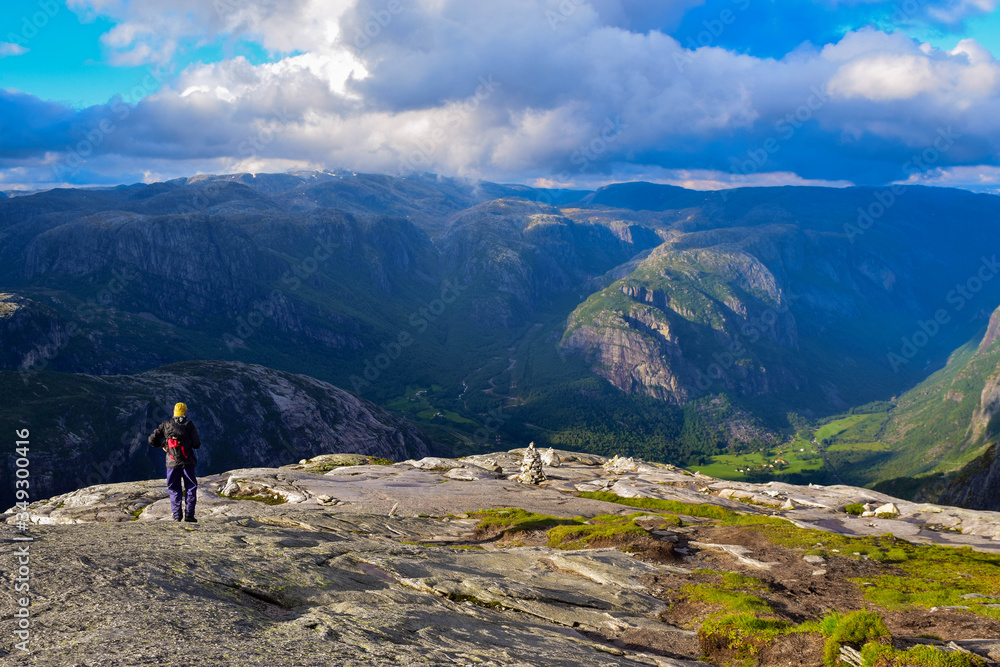 Obraz premium Tourist man on trail to Kjeragbolten. Amazing landscapes of the Norwegian mountains.