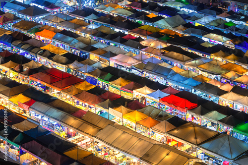 Bangkok, Thailand, Top view of Train Night Market Ratchada flea market with plenty of shops with colorful canvas and amazing pattern of roofs near MRT line at night time in Bangkok photo