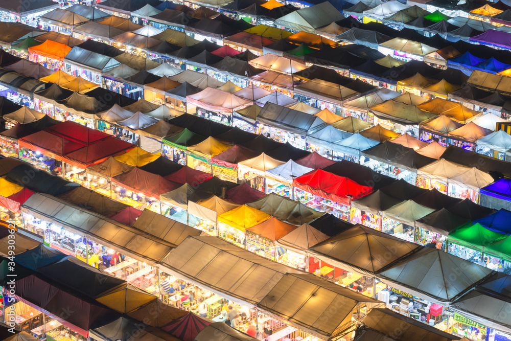 Bangkok, Thailand, Top view of Train Night Market Ratchada flea market with plenty of shops with colorful canvas and amazing pattern of roofs near MRT line at night time in Bangkok