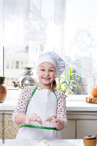 Little girl bakes pies in the kitchen
