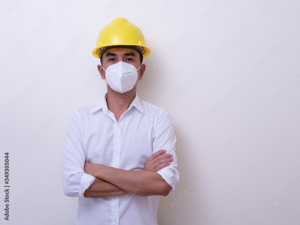 Asian industrial workers wear yellow hard hats, wear protective masks for their health Asian industrial workers wear yellow hard hats, wear protective masks for their health