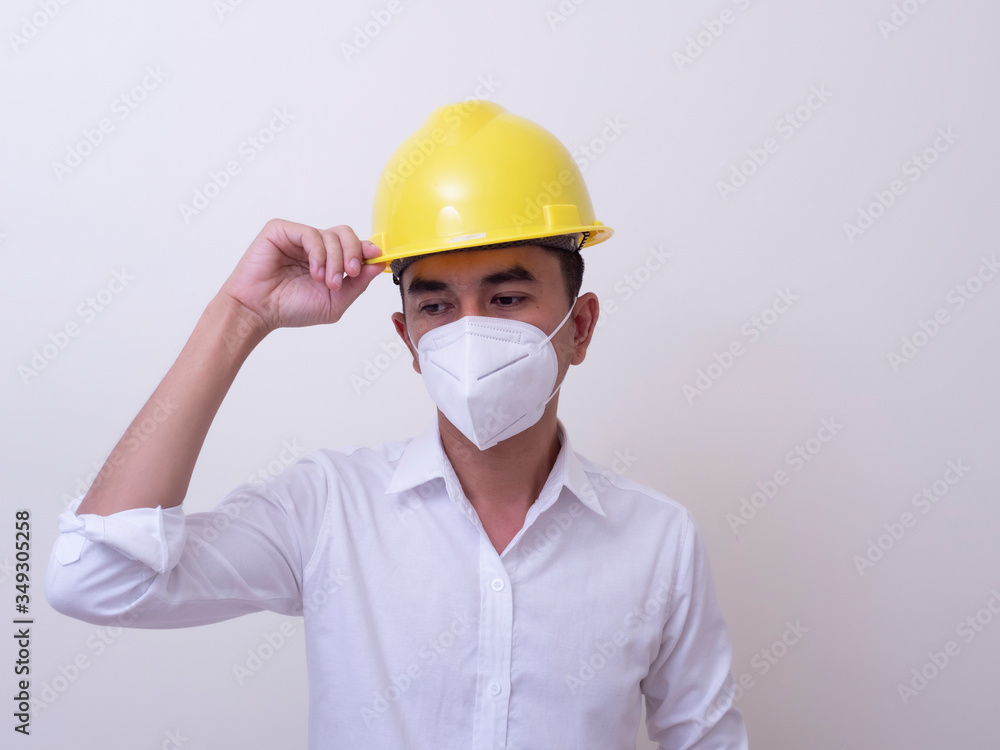 Asian industrial workers wear yellow hard hats, wear protective masks for their health Asian industrial workers wear yellow hard hats, wear protective masks for their health