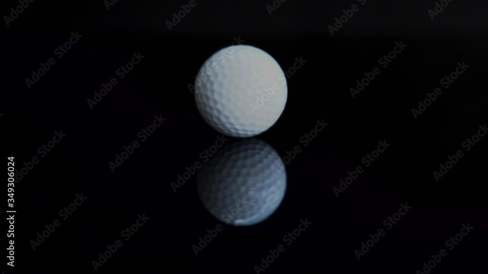 Golf ball white color turn rotating on black background with reflection. Golf ball white color turn rotating on black background with reflection.