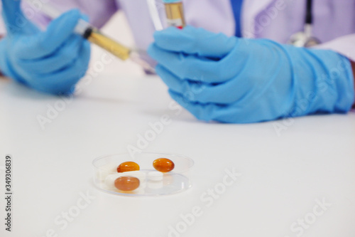 Close up of medicine and laboratory assistant's hands with syring on background © Supitnan