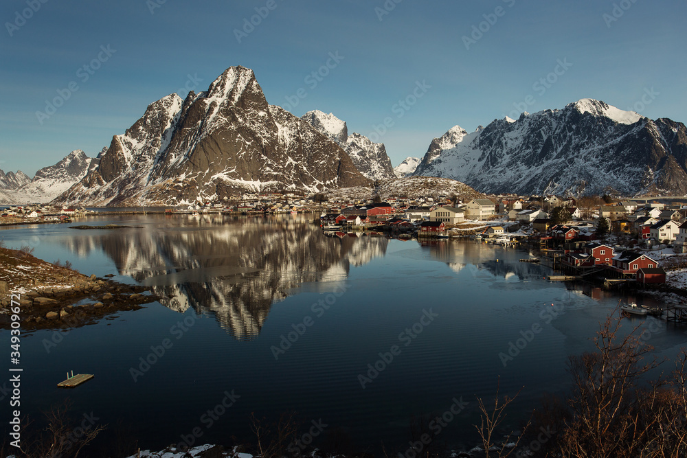 Obraz premium View of beautiful Sacrisoya village in winter time with montains in background with light of sunrise. Lofoten, Norway.