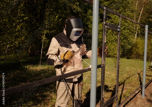 welder welds metal in nature with sparks