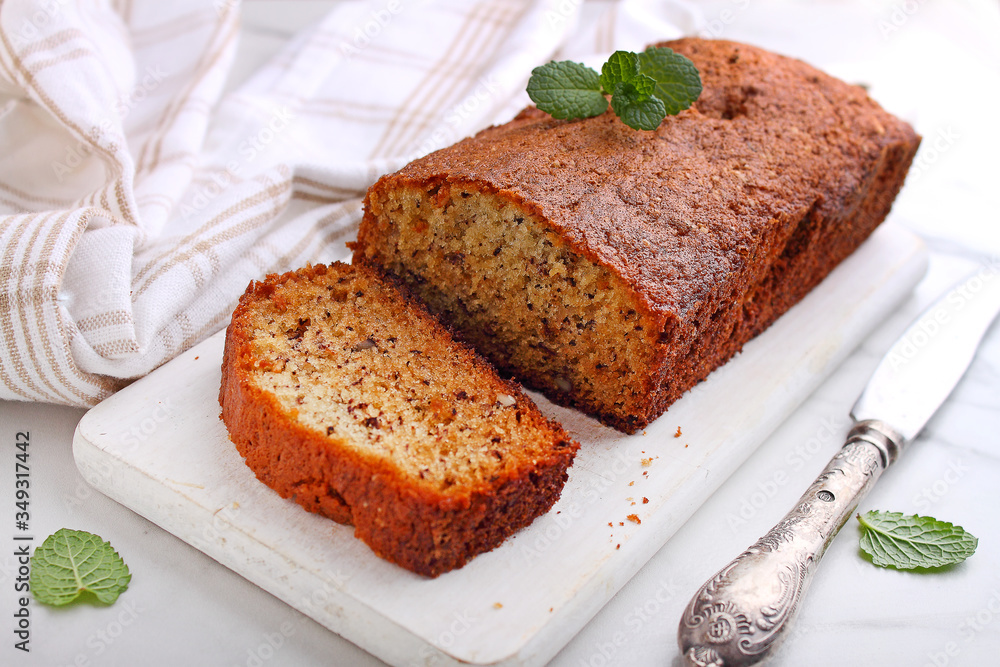 Fresh baked banana cake with nuts on a light background, decorated with mint