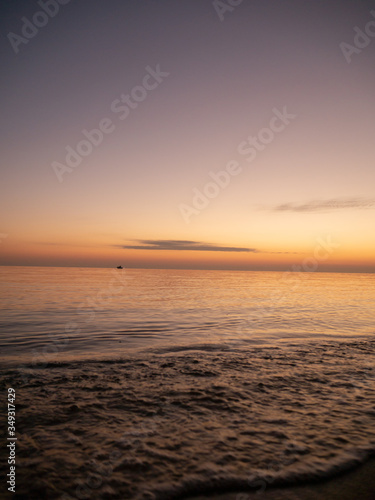 Sunset on small waves seaside beach