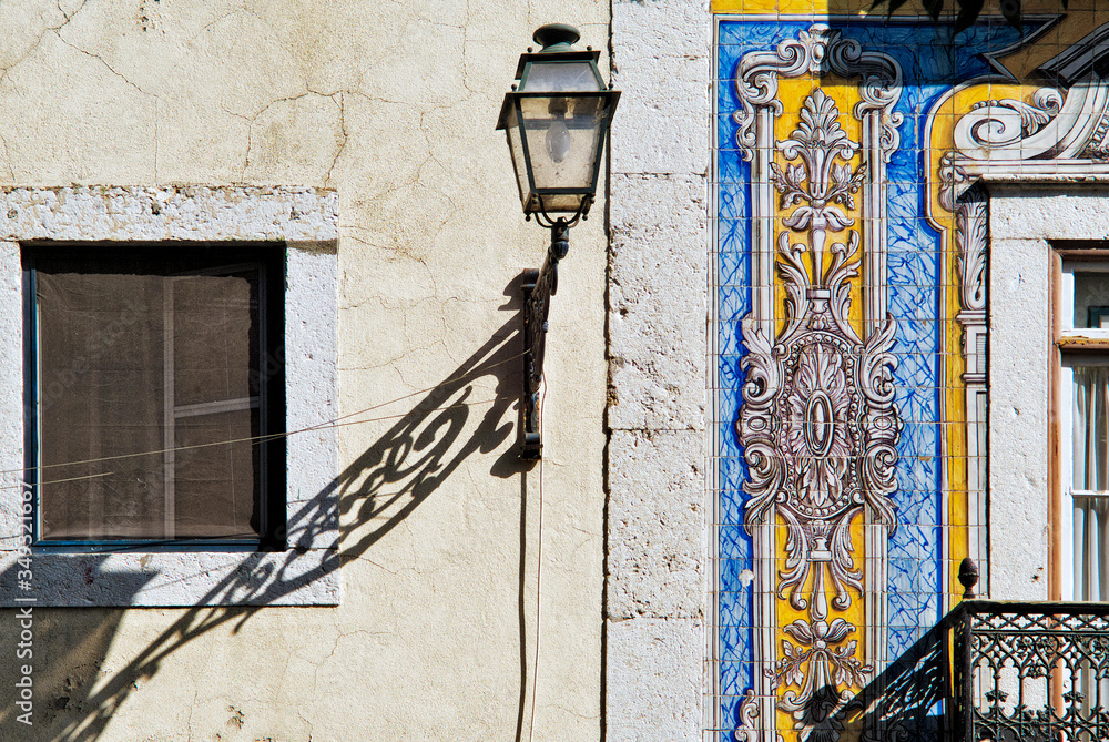 old street lamp on a facade covered with lisbon azulejos