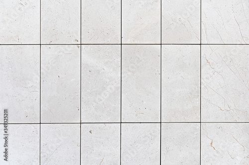 The wall from white ceramic tile. The outer wall is made of white ceramic rectangular tiles. Vertical masonry tiles. Background. 