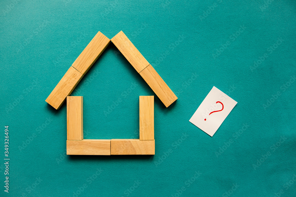 House made of wooden blocks and red question mark on a blue background ...