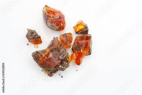 Japanese amber on a white background. Pieces of sun stone on a light substrate. Many different colored pieces of petrified wood resin. Fossil copal. Natural minerals for jewelers. Crystal. Japan amber