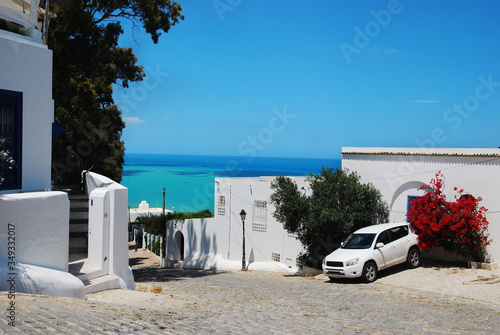 View of the blue sea and the street with white houses in Sidi Bou Said in Tunisia in summer in sunny weather