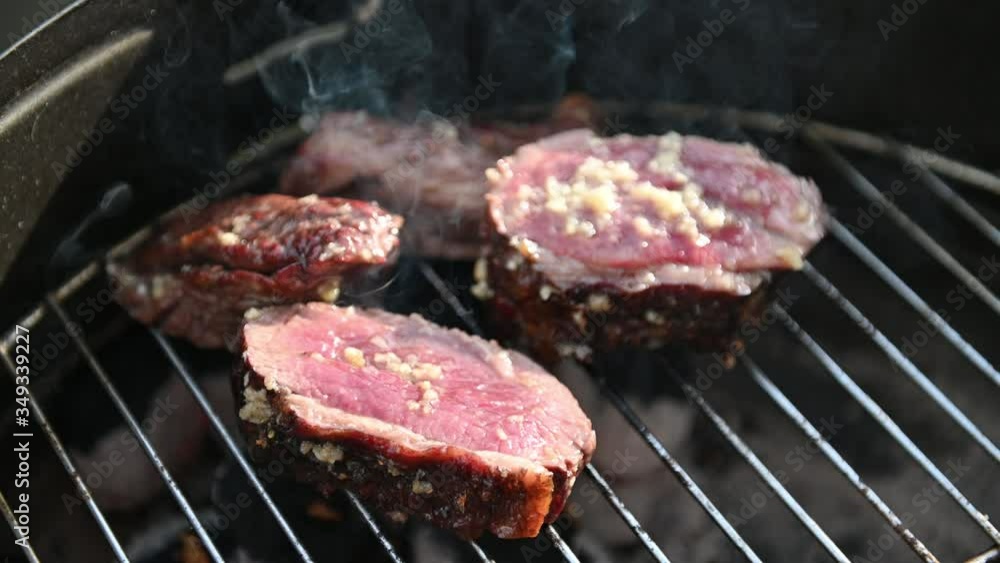 Grilled beef steaks with garlic. Selective focus. Video 4K. Grilled beef steaks with garlic. Selective focus. Video 4K.