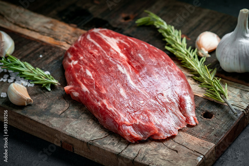 Raw flank beef steak and ingredients for cooking on a wooden Board, close up photo