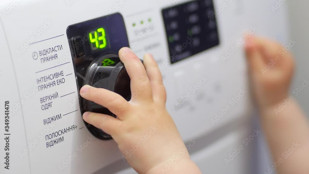 The Child Switches the Washing Machine Modes. The Small Child's Handle Rotates the Washing Modes Switch. The Child Switches the Washing Machine Modes. The Small Child's Handle Rotates the Washing Modes Switch.
