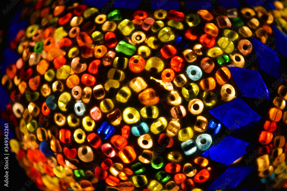 Bright multi-color mosaic, luminous fresco from large beads and colored glass. Beautiful, colorful pattern of flowers laid out in the form of the sun. Bright multi-color mosaic, luminous fresco from large beads and colored glass. Beautiful, colorful pattern of flowers laid out in the form of the sun.