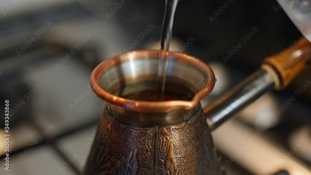 Boil coffee from the Turks. On the gas stove is a copper engraved Turk with a running coffee. Running coffee close up. Boil coffee from the Turks. On the gas stove is a copper engraved Turk with a running coffee. Running coffee close up.