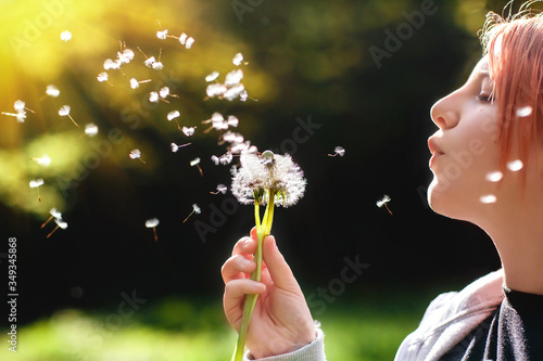 girl blowing on a dandelion