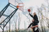 Happy young couple is playing basketball together