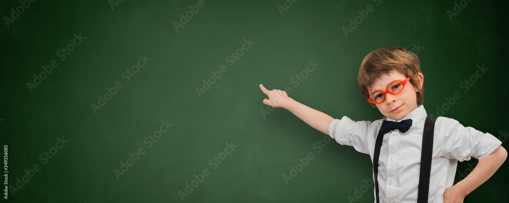 Boy points his finger at an empty blackboard banner