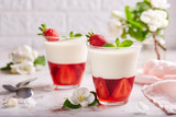 Layered dessert in glass with vanilla panna cotta and jelly with strawberries