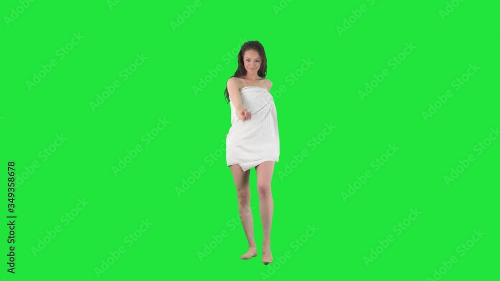 Back view of young seductive woman in towel turning to camera and inviting and beckoning with finger. Full body isolated on green screen background. Back view of young seductive woman in towel turning to camera and inviting and beckoning with finger. Full body isolated on green screen background.