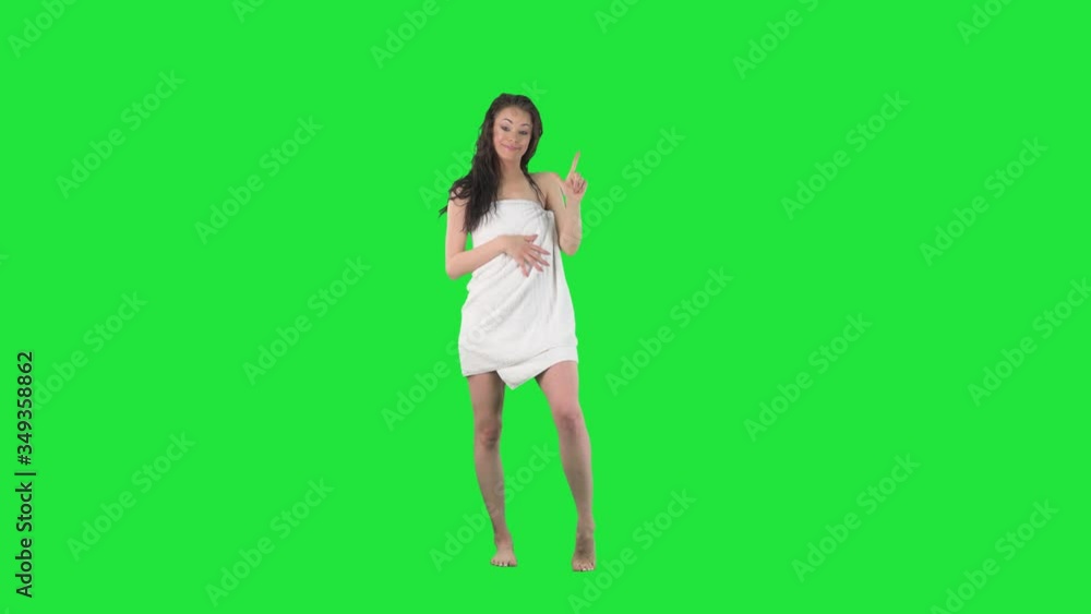 Happy young smiling woman in bath towel counting to number five with her fingers. Full body isolated on green screen background. Happy young smiling woman in bath towel counting to number five with her fingers. Full body isolated on green screen background.