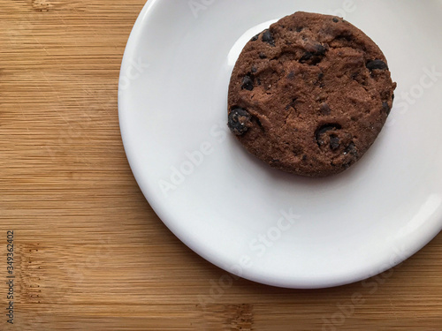 homemade cookie with chocolate on white plate and wooden desk