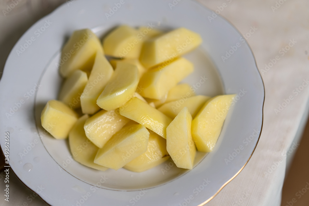 Sliced raw potatoes lie in a plate Sliced raw potatoes lie in a plate