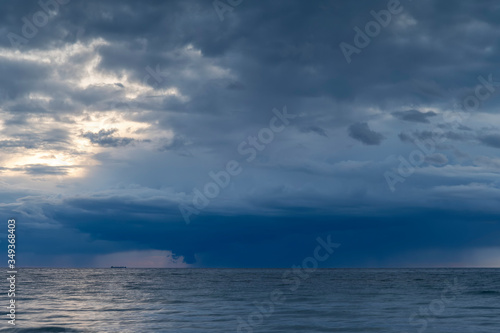 Fototapeta Naklejka Na Ścianę i Meble -  Heavy rainfall over ocean during sunset