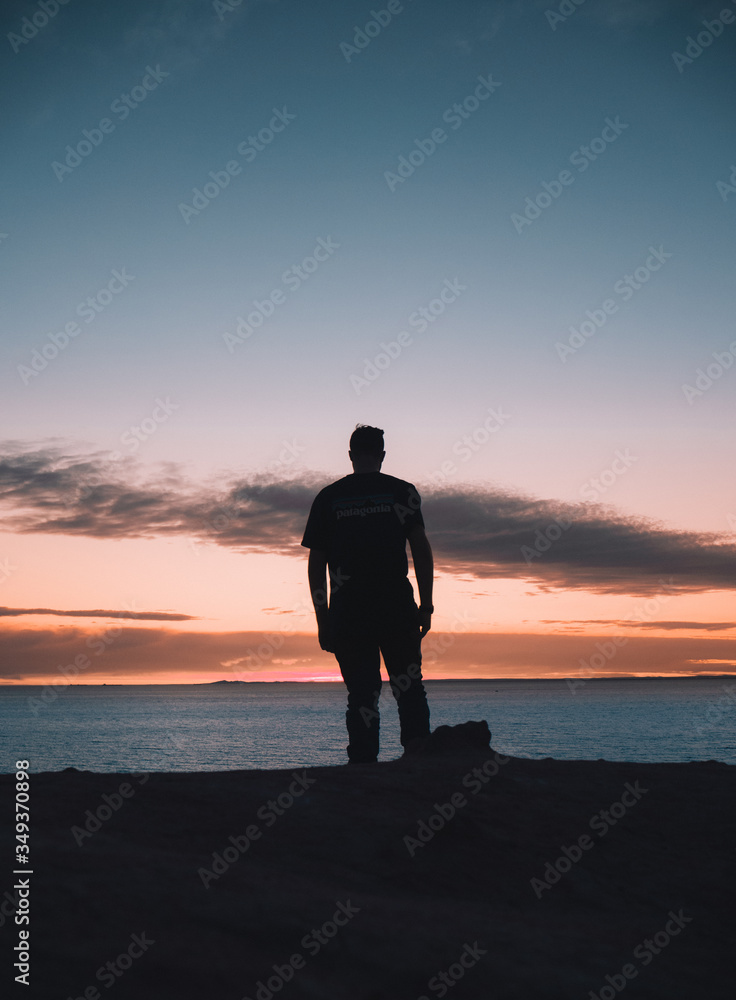 Person silhouette at beach sunset orange