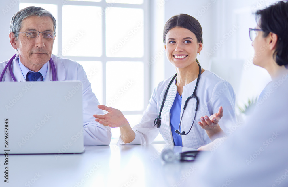 Serious medical team discussing patient's case in a bright office Serious medical team discussing patient's case in a bright office