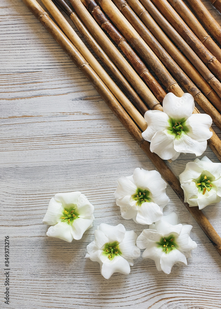 Top view of bamboo, white flowers and wood background. Clean beauty concept, spa, сlean beauty concept. Your product here. Space for a text. Flat lay. Top view of bamboo, white flowers and wood background. Clean beauty concept, spa, сlean beauty concept. Your product here. Space for a text. Flat lay.