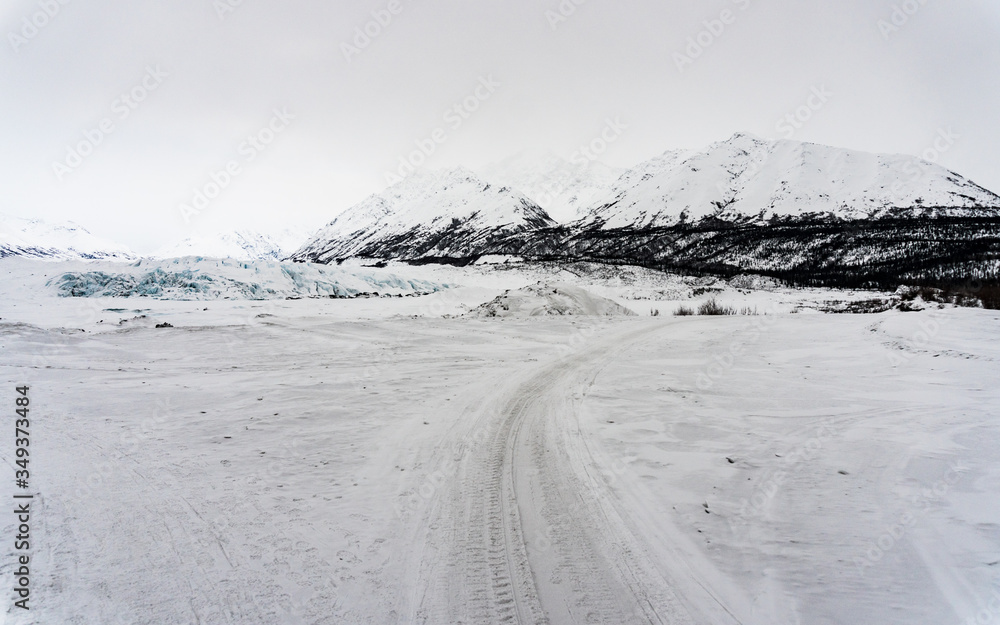 Path to Matanuska glacier in the winter. It.s surrounded by mountains and snow. Taken from the distance while trekking to the ice caves. It's empty and lonely. Near Anchorage, in Alaska. 