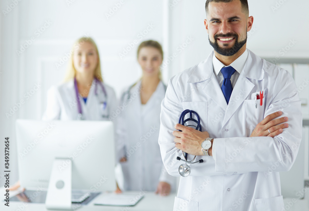 Young male doctor in front of medical group Young male doctor in front of medical group