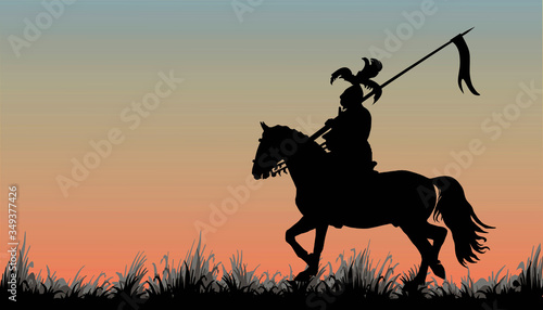 black silhouette of a medieval knight with a spear on a horse in a field  trotting  isolated image on the background of the dawn sky