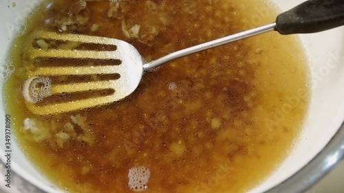 Dirty greasy pan with a spatula. Droplets of oil mixed with water. Slow rotation