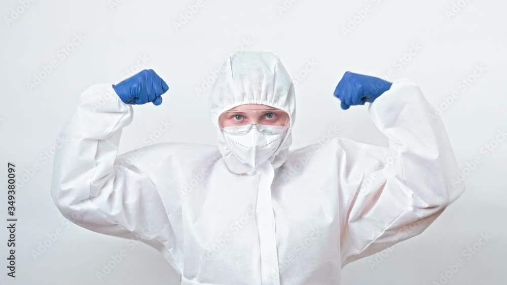 Medical worker. Coronavirus outbreak. Brave female doctor in white protective suit showing strength. Medical worker. Coronavirus outbreak. Brave female doctor in white protective suit showing strength.