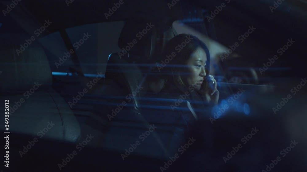 A woman sits in a car at night and speaks on the phone A woman sits in a car at night and speaks on the phone