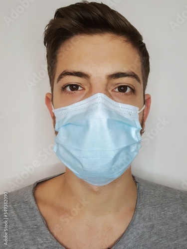 bel ragazzo indossa la maschera per proteggersi dal virus photo