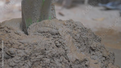 Wallpaper Mural construction worker mixes wet grey cement holding green shovel on ground slow motion close view. Concept slavery and poverty Torontodigital.ca