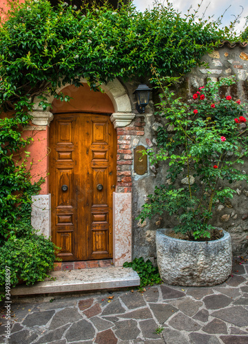 A beautiful old wooden door surrounded by plants in old town Verona Italy