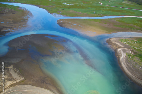 Obraz na płótnie Turquoise, blue, green, river flowing smoothly through dirt waterway in Alaska
