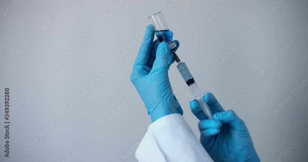 Medicine vaccination equipment with needle and ampoule in doctor or nurse hand isolated on white background. Health care concept. Hand holding syringe and vaccine. Ampoule with a vaccine blue Medicine vaccination equipment with needle and ampoule in doctor or nurse hand isolated on white background. Health care concept. Hand holding syringe and vaccine. Ampoule with a vaccine blue