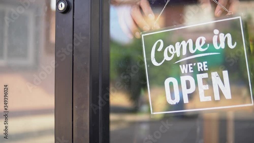 A small business closing down. Turning the sign from open to close.
