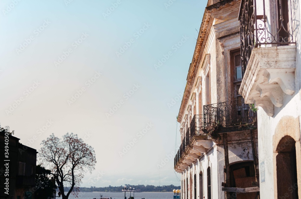 A medium sized colonial house with white dirty walls and full of windows with a side view of Rio de La Plata. A medium sized colonial house with white dirty walls and full of windows with a side view of Rio de La Plata.